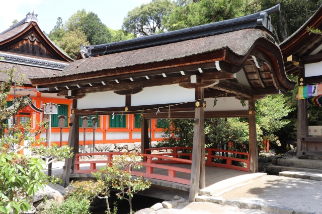 上賀茂神社 縁結び ご利益 屋根の橋殿と、朱色の欄干が美しい上賀茂神社の橋。奥には本殿の建物が見える。